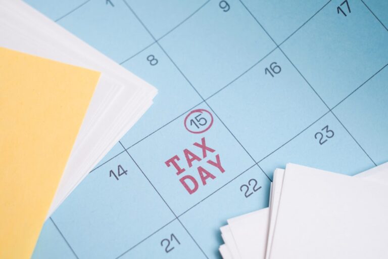 A family at a kitchen table reviewing paperwork and smiling while organizing tax documents.