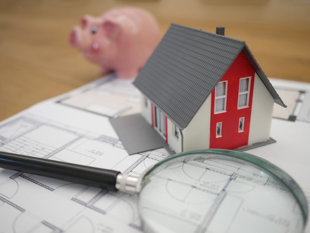 Homebuyer reviewing a closing folder, mortgage statement, property tax bill, and calculator at a kitchen table.