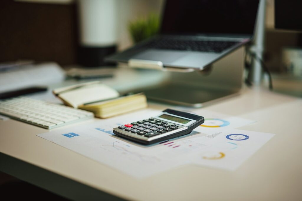 Small business owner reviewing receipts, mileage records, and tax documents at a home office desk.