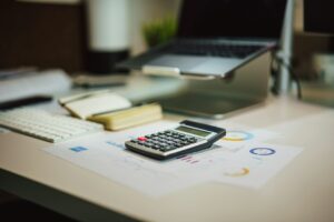 Small business owner reviewing receipts, mileage records, and tax documents at a home office desk.